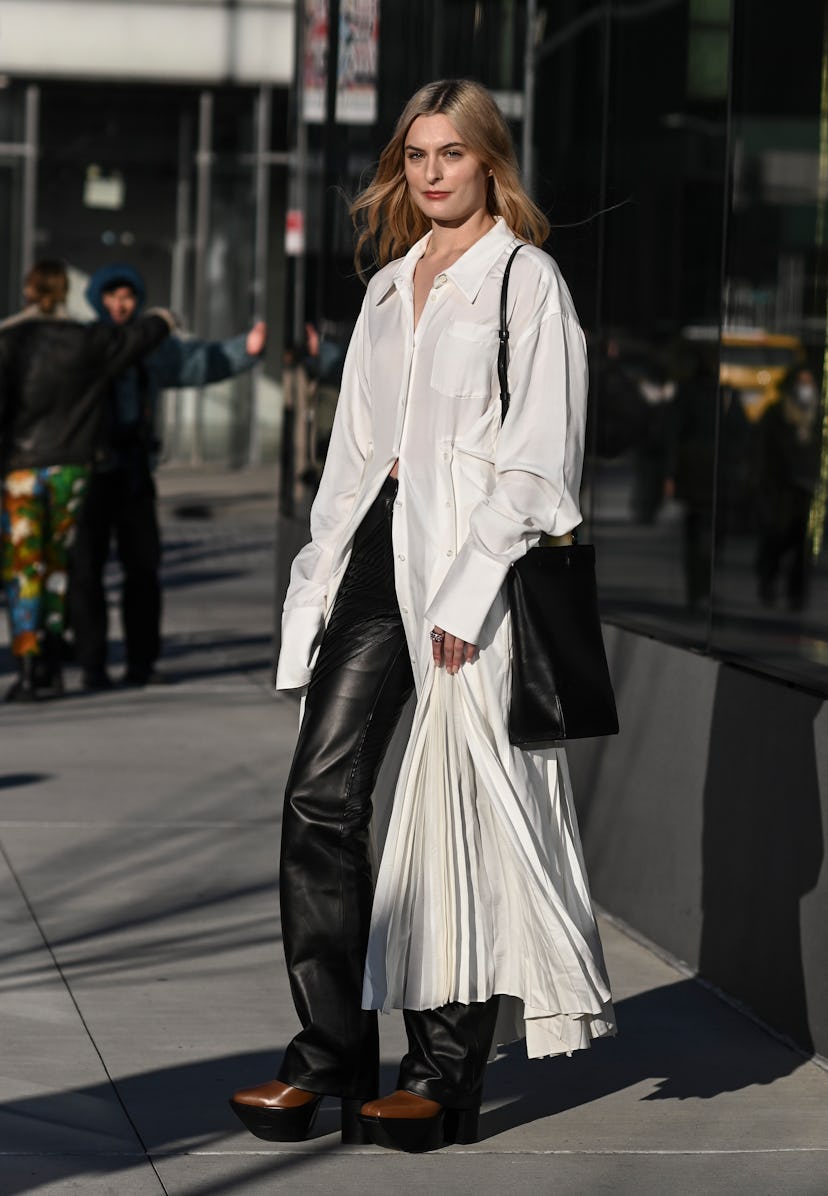 NEW YORK, NEW YORK - FEBRUARY 15: A guest is seen wearing a shirt dress and black pants outside the ...