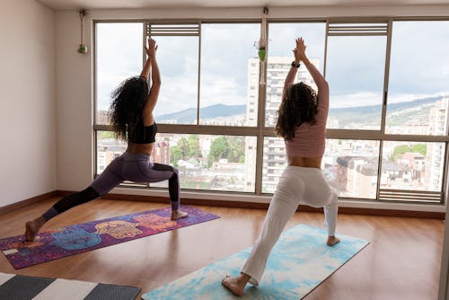 Two women do yoga. Here's your daily horoscope for February 22, 2022.
