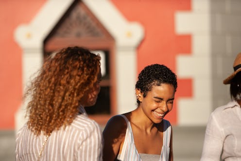 A young woman laughing with a friend on a sunny day. Aquarius season falls between Jan. 20 and Feb. ...