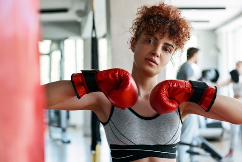 Young woman kickboxing at the gym. Aries zodiac signs hidden powers include superhuman strength, reg...