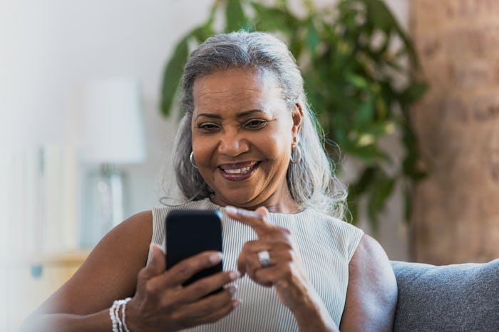 Sitting in her living room, the grandmother smiles as she video chats with her grandchildren.