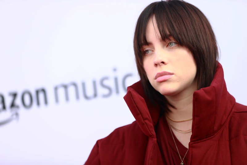 Singer Billie Eilish in a dark maroon coat.