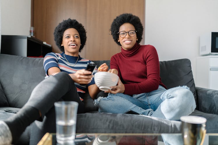 Twin sisters are sitting on sofa and thinking of a sister group name for the group chat.