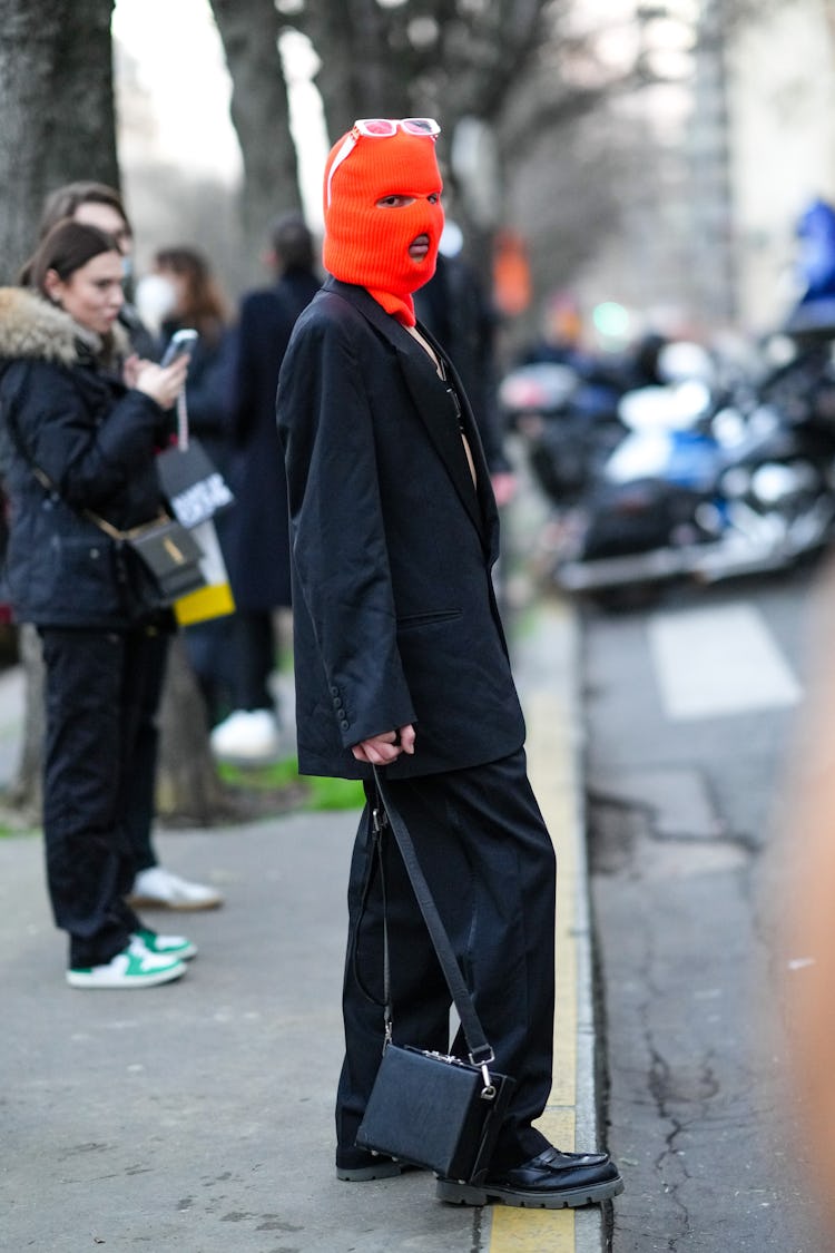 PARIS, FRANCE - JANUARY 21: A guest wears white sunglasses, neon red ribbed baclava, a black oversiz...