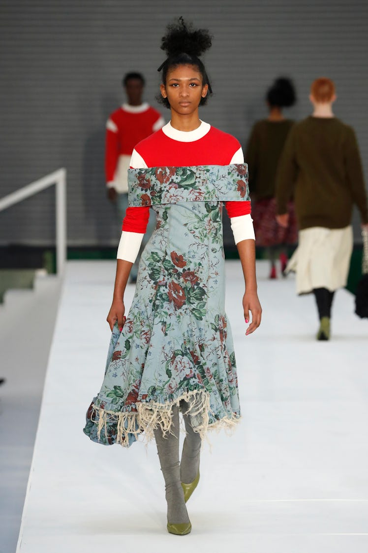 A model in a red-white shirt and a blue floral dress by Molly Goddard at the London Fashion Week Fal...