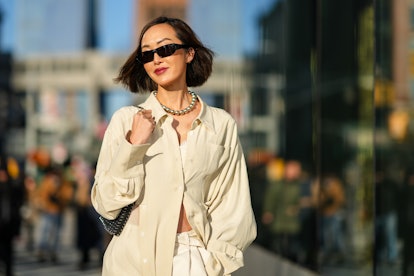 NEW YORK, NEW YORK - FEBRUARY 15: Chriselle Lim wears black sunglasses, gold earrings, a silver shin...