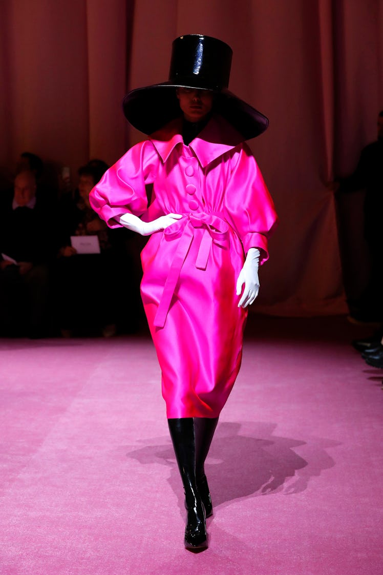 A model in a pink coat and large black hat by Richard Quinn at the London Fashion Week Fall 2022
