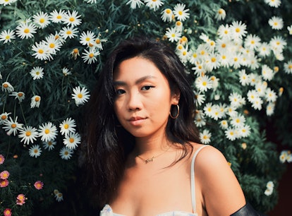Young woman posing in front of daisies, knowing the week of February 28, 2022 will be the worst for ...