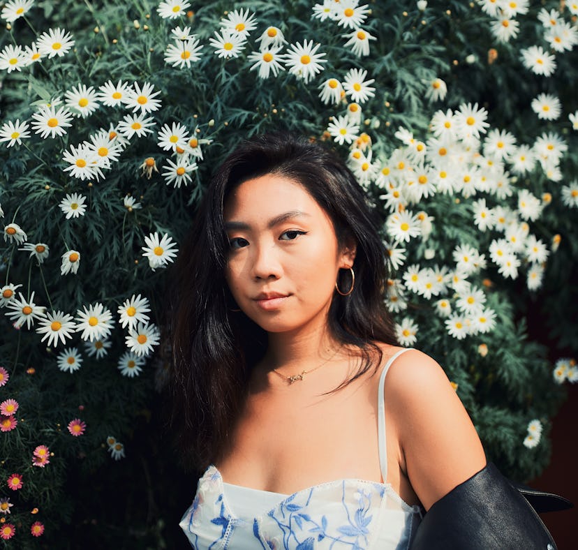 Young woman posing in front of daisies, knowing the week of February 28, 2022 will be the worst for ...