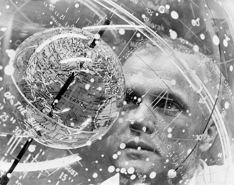 (1961) Astronaut John H. Glenn Jr. looks into a Celestial Training Device (globe) during training in...