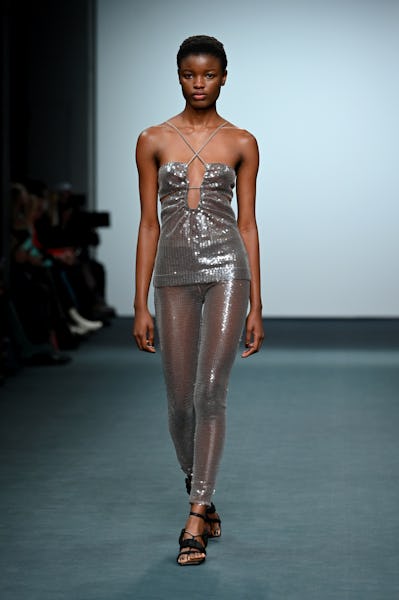 a model wearing a silver sequin top and leggings on the Nensi Dojaka runway
