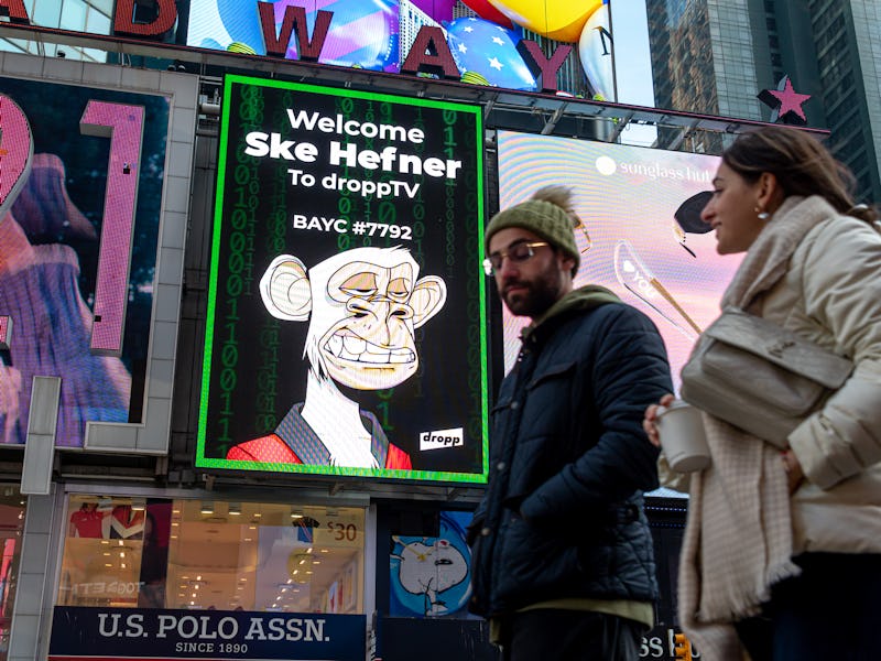 NEW YORK, NEW YORK - JANUARY 25: People walk by a Bored Ape Yacht Club NFT billboard in Times Square...