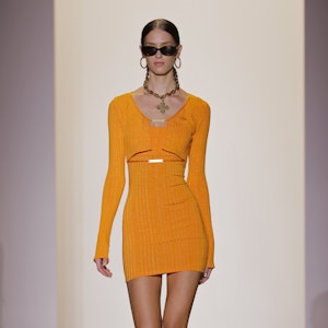 a model wearing a marigold knit mini dress on the Hardware LDN runway