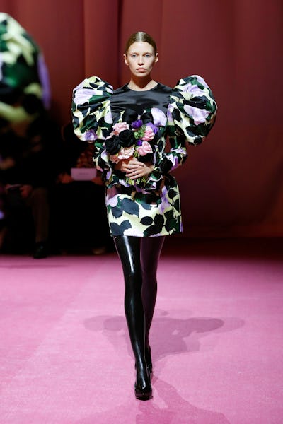 a model wearing a printed mini dress with voluminous shoulders on the Richard Quinn runway