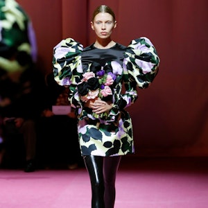 a model wearing a printed mini dress with voluminous shoulders on the Richard Quinn runway