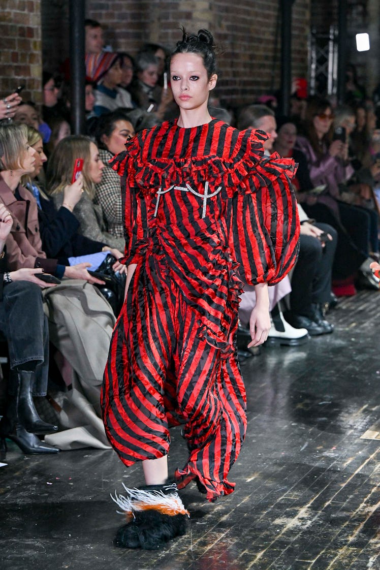 A model a Preen by Thornton Bregazzi wearing a black-red striped dress at the London Fashion Week Fa...