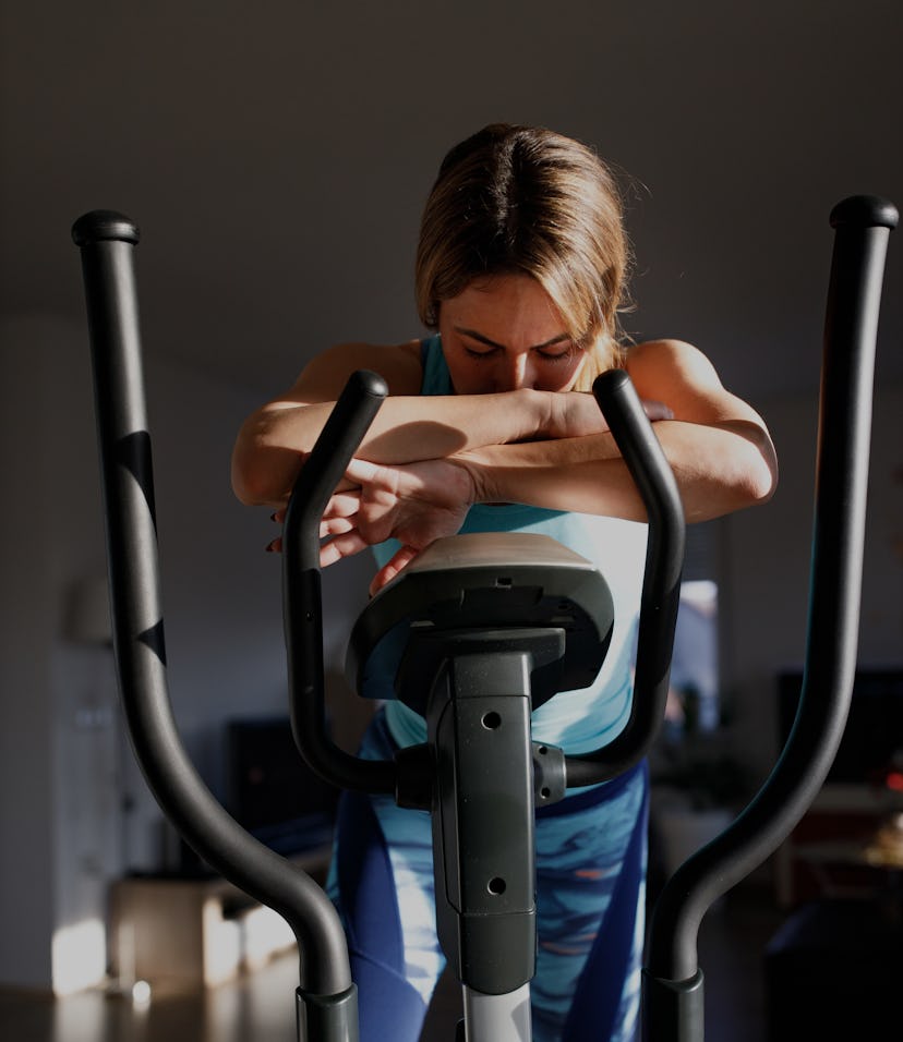 A tired woman is resting after training on a exercise bike