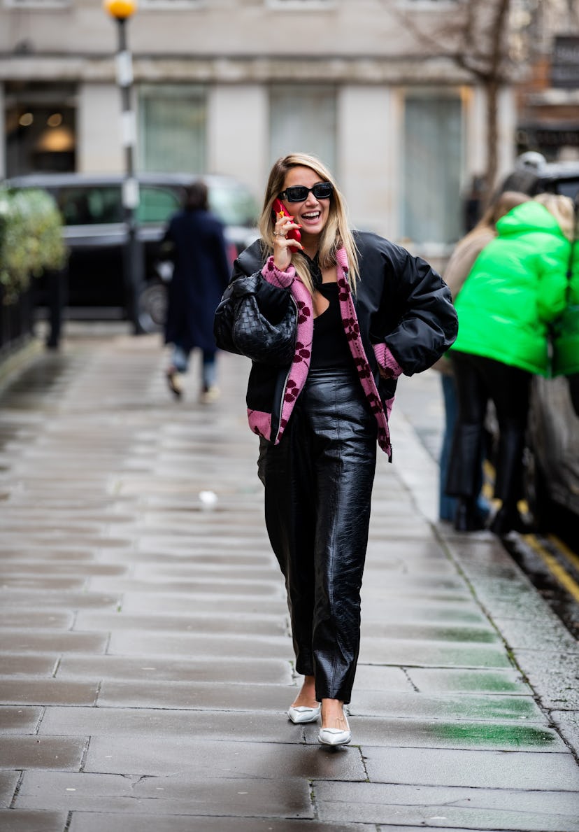 LONDON, ENGLAND - FEBRUARY 19: A guest is seen wearing black Bottega Veneta bag, bomber jacket ,blac...
