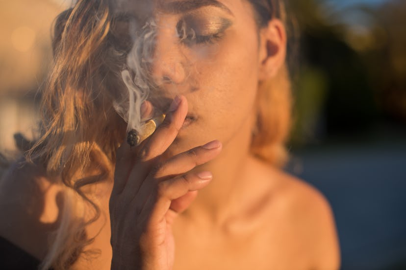Portrait shot up close of woman smoking marijuana
