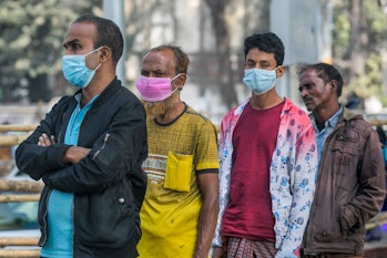DHAKA, BANGLADESH - 2022/02/14: Homeless people wait in a queue to be vaccinated with a dose of the ...
