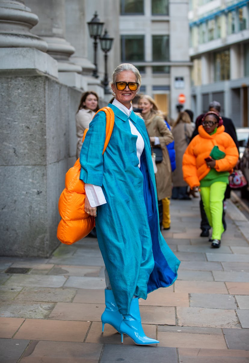 LONDON, ENGLAND - FEBRUARY 18: Mette Sorrig is seen wearing orange oversized bag, blue coat, ankle b...