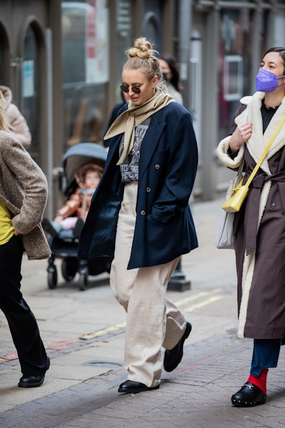 LONDON, ENGLAND - FEBRUARY 21: A guest is seen wearing navy blazer, beige pants outside Preen during...