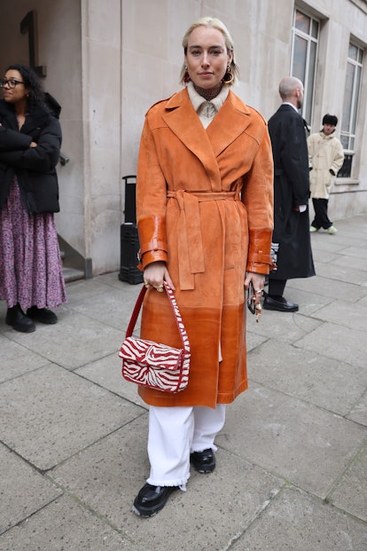 LONDON, ENGLAND - FEBRUARY 18: Guest in orange coat attends Poster Girl show at 1 Harewood Avenue du...