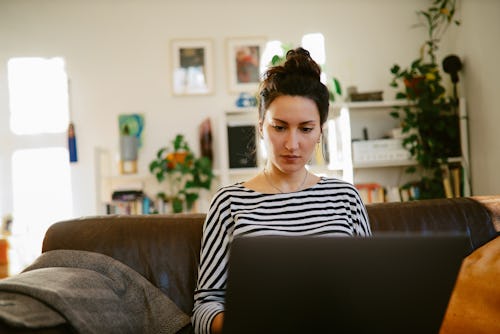 A woman in a striped shirt uses LinkedIn to find a new job.