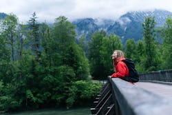 A woman sits on a bridge during a rainy hike. Here are all the astrological events happening in Marc...