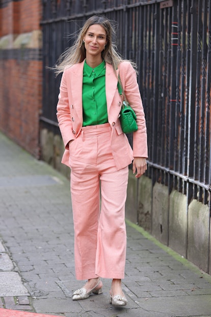 LONDON, ENGLAND - FEBRUARY 18: Isabella Charlotta Poppius wearing pink trouser suit, green shirt and...