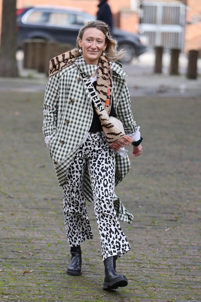 LONDON, ENGLAND - FEBRUARY 18: Guest in white leopard print trousers, checkered coat, Stella McCartn...