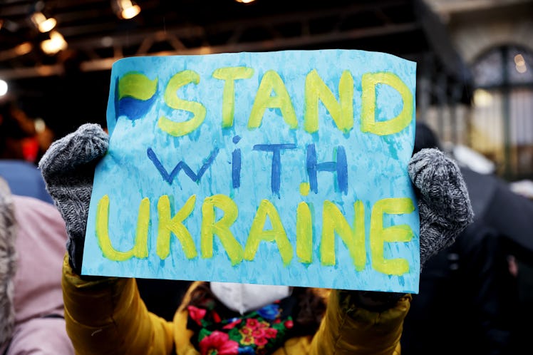 24 February 2022, North Rhine-Westphalia, Duesseldorf: A demonstrator holds a placard with the inscr...