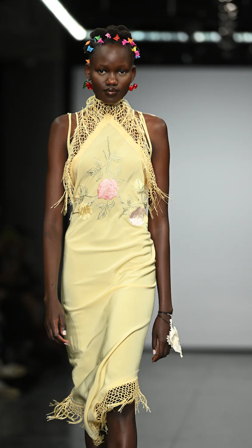 At London Fashion Week F/W 2022, a model walks the runway at the Conner Ives show with butterfly cli...