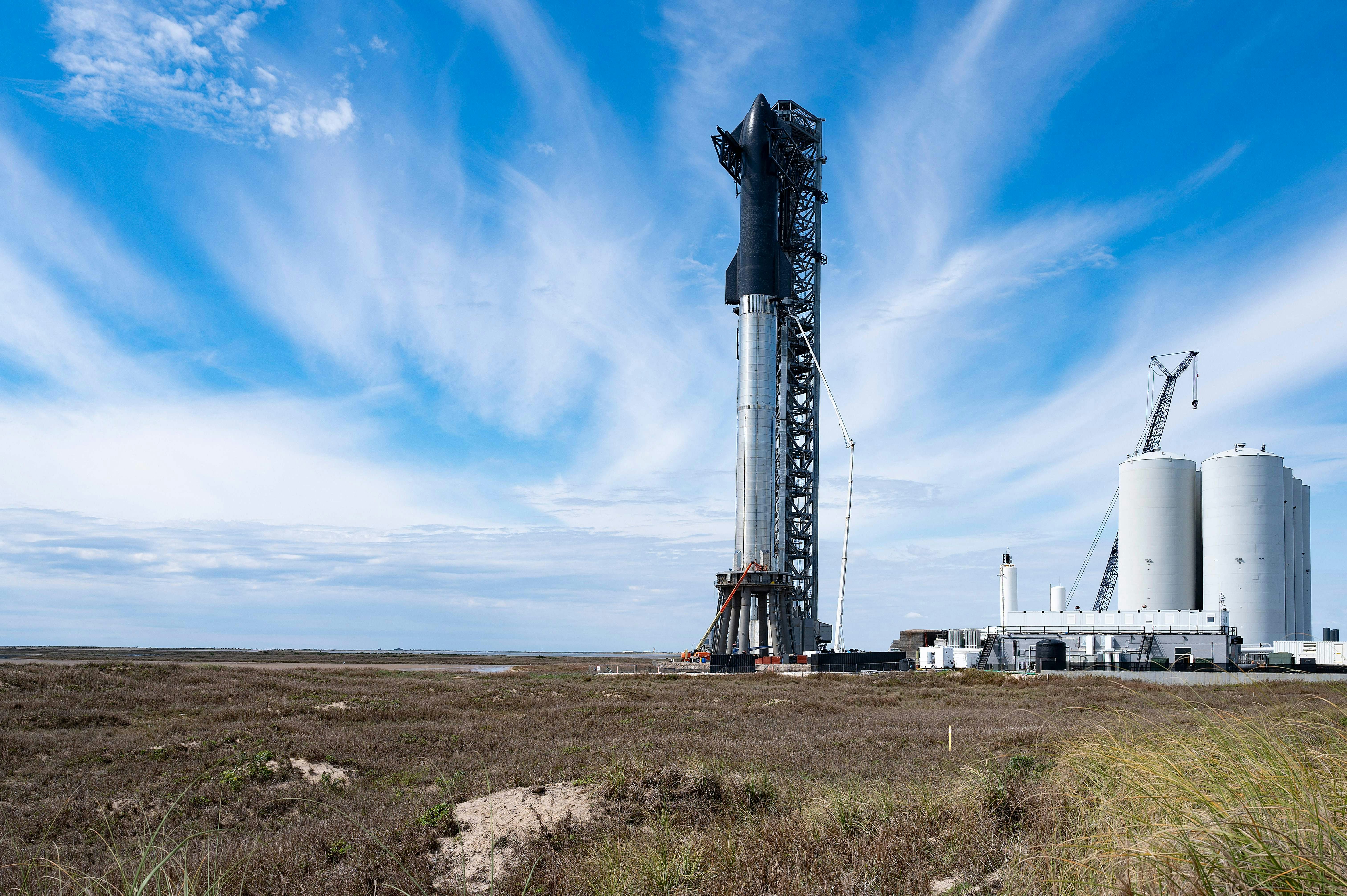 SpaceX's first orbital Starship SN20 is stacked atop its massive Super Heavy Booster 4 at the compan...