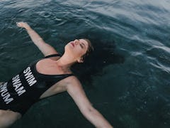 Young woman on her back enjoying in calm water, knowing her zodiac sign will be affected by the Marc...