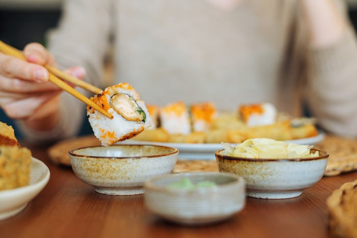 Close up of woman eating maki sushi