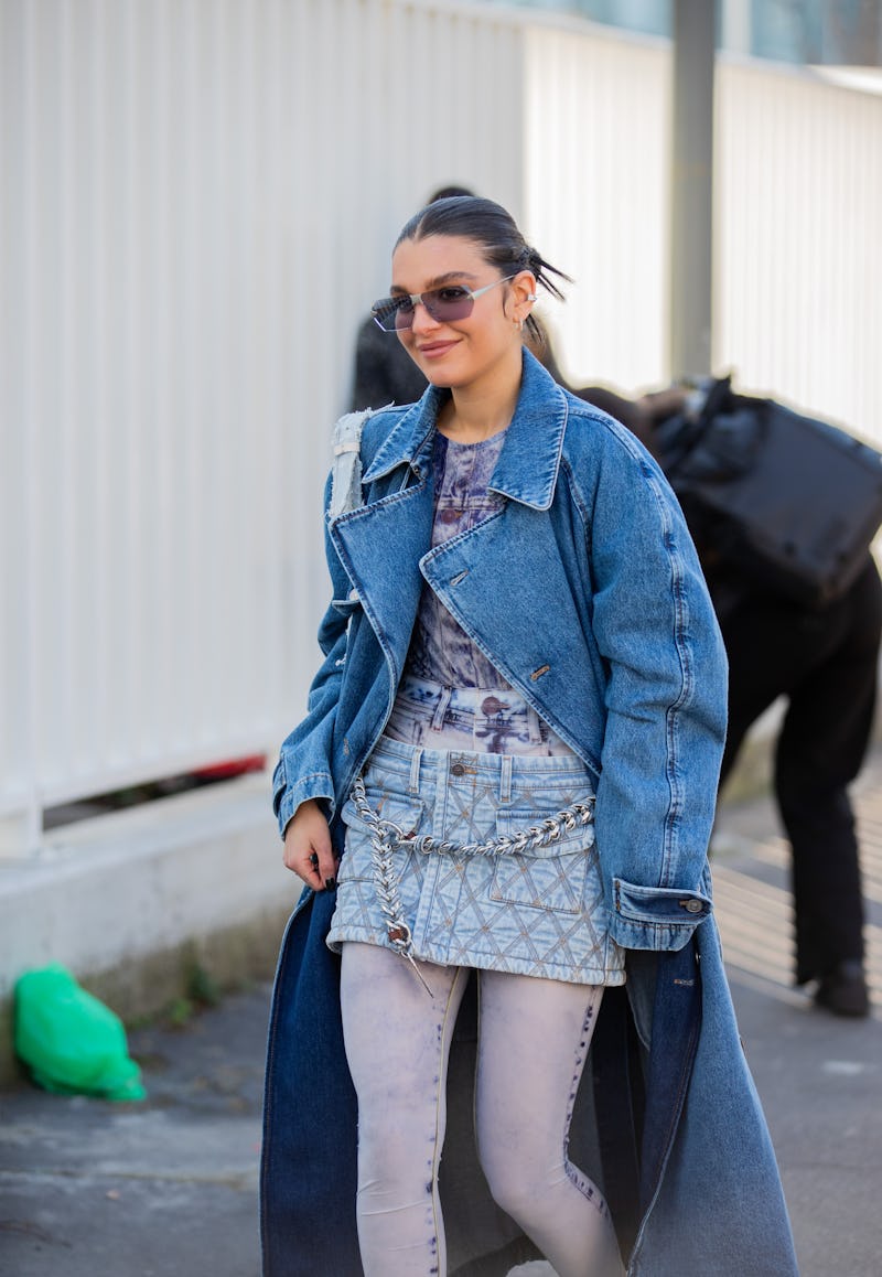 MILAN, ITALY - FEBRUARY 23: Maria Chervotkina is seen wearing denim coat, skirt, white tights, bag, ...