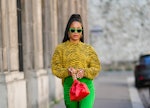 PARIS, FRANCE - JANUARY 14: Ellie Delphine wears neon green sunglasses, gold earrings, a yellow and ...