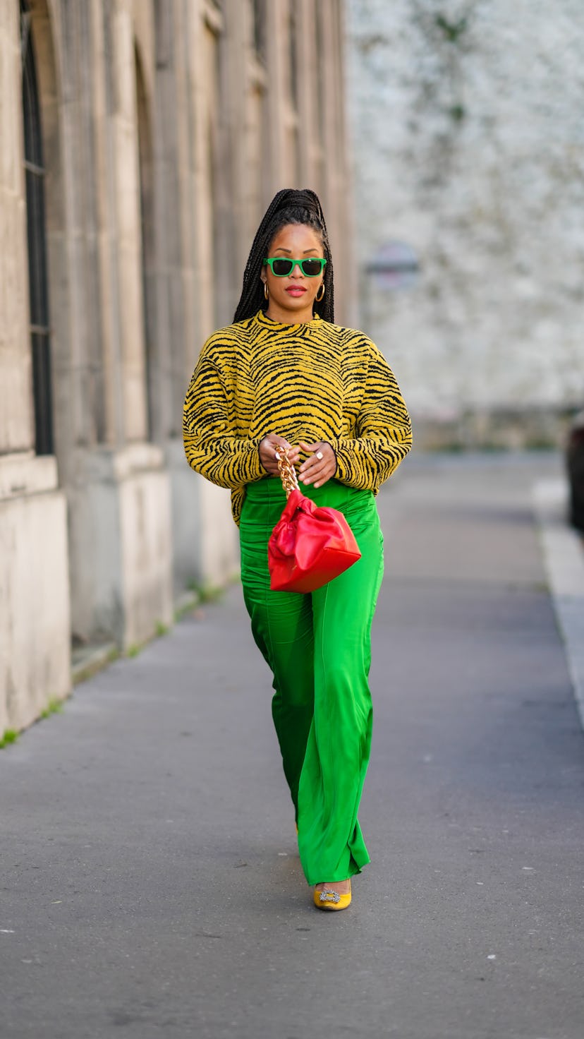 PARIS, FRANCE - JANUARY 14: Ellie Delphine wears neon green sunglasses, gold earrings, a yellow and ...