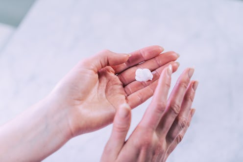 Pretty manicured female hands applying hand cream. Skin care.