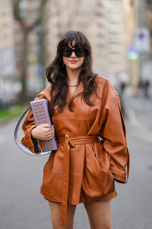 MILAN, ITALY - FEBRUARY 24: Gili Biegun wears black sunglasses, gold earrings, a gold and silver nec...