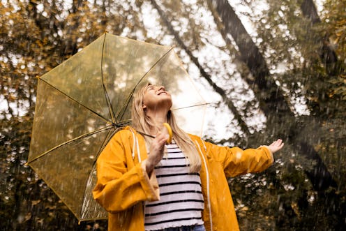 Beautiful young woman enjoying a rainy day