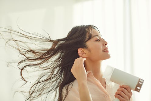 woman blowdrying her hair