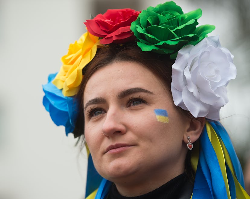 MALAGA, SPAIN - 2022/02/27: A woman dressed with flowers of Ukraine is seen looking out during an an...