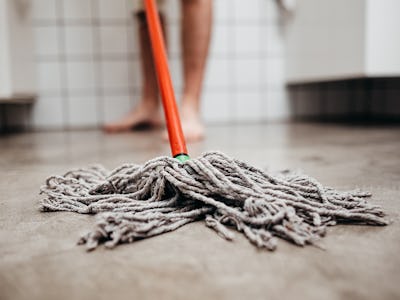 After taking a shower, a man collects water with a jog in the bathroom