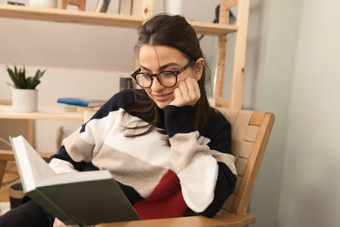 Portrait of a beautiful girl enjoying reading a book at home