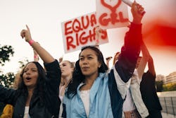 Activists hold up signs at a protest. This is the best career for aquarius zodiac signs.