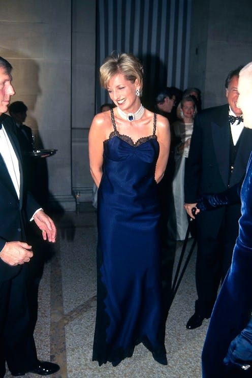 Princess Diana attends the Met Gala in 1995 wearing a navy blue slip dress.