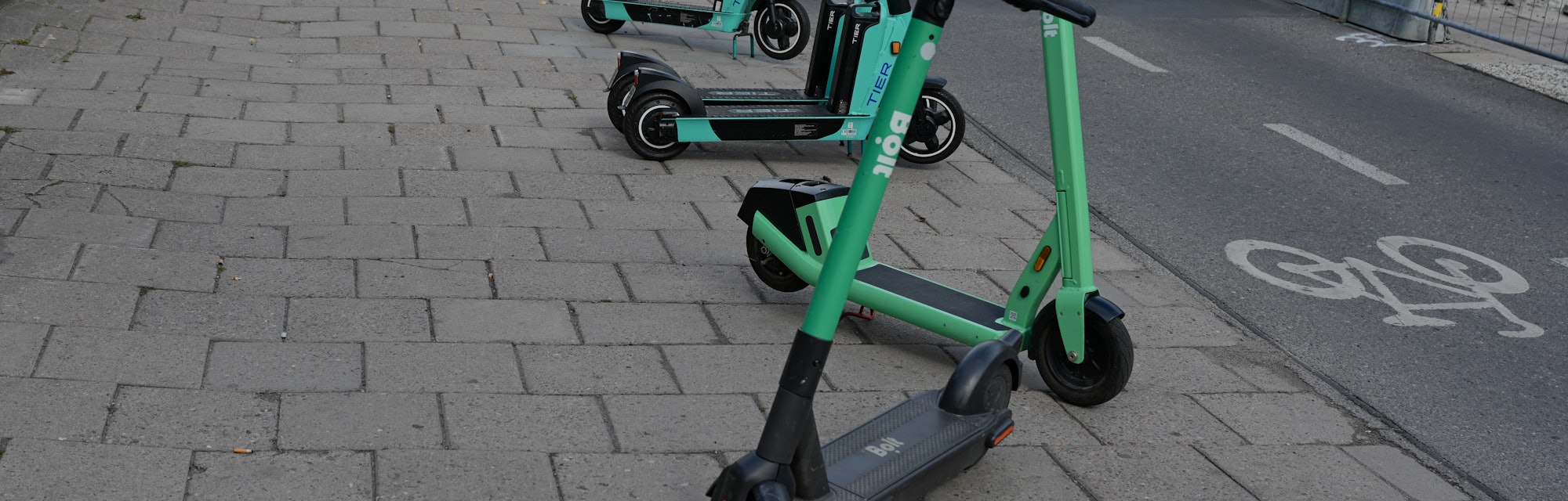 STOCKHOLM, SWEDEN - August 15, 2021: Electric scooters parked on pavement is Stockholm, Sweden.  The...