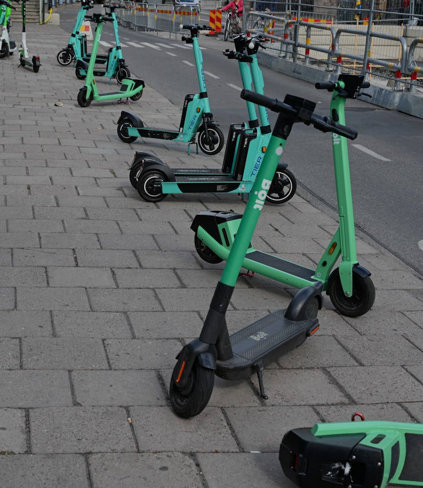 STOCKHOLM, SWEDEN - August 15, 2021: Electric scooters parked on pavement is Stockholm, Sweden. The...